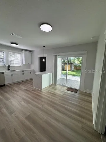 a view of a kitchen with wooden floor and electronic appliances