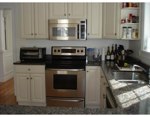 10 Chestnut Lane, Unit 12 Lexington, MA 02421 - Photo 6 of 11 a kitchen with granite countertop a stove microwave and sink