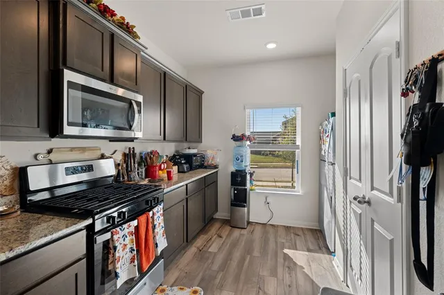 a kitchen with a sink dishwasher stove and cabinets