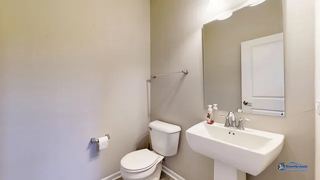 a bathroom with a sink mirror and toilet