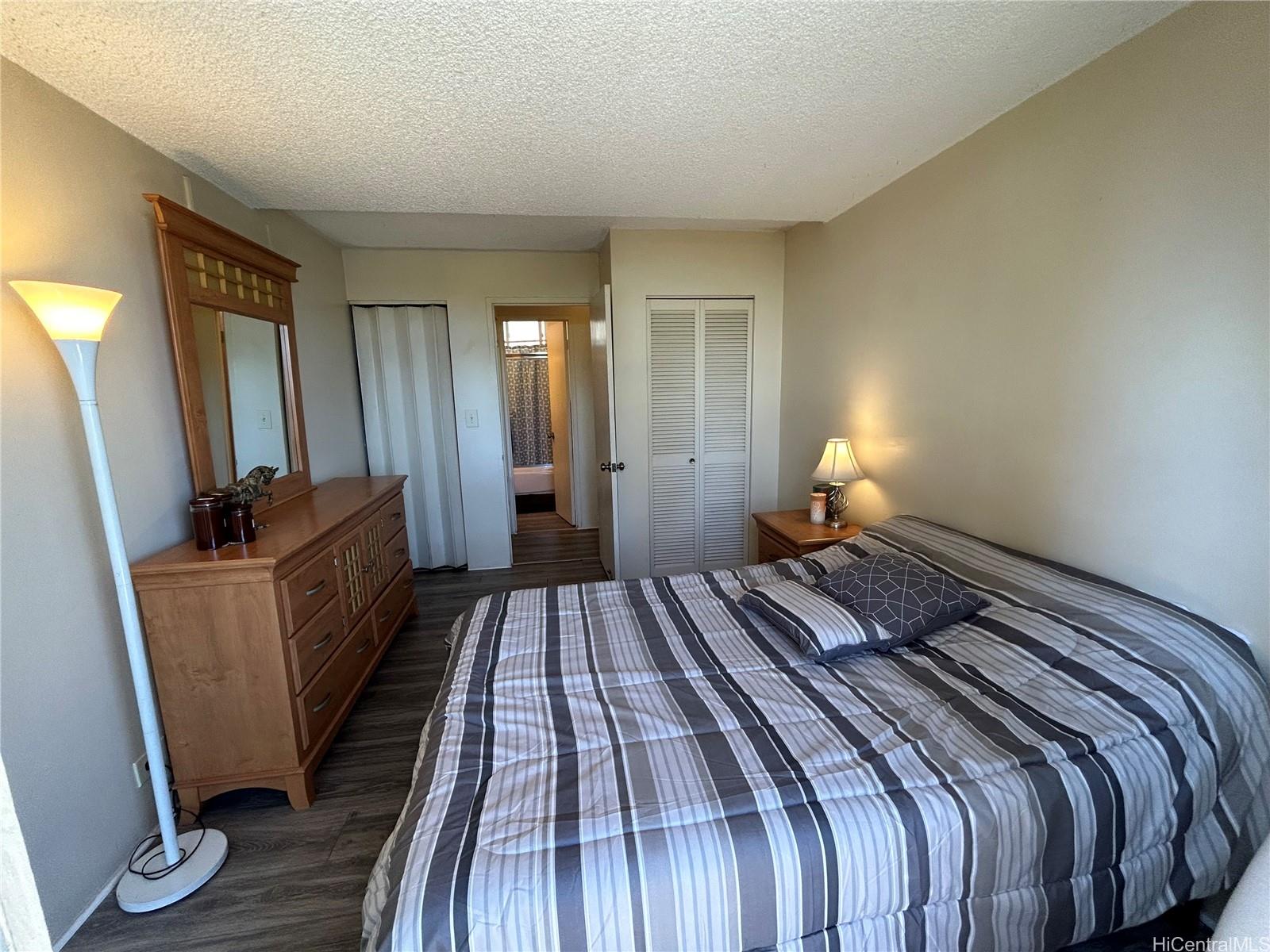 454 Nāmāhana Street, Unit 701 Honolulu, HI 96815 - Photo 17 of 25 a bedroom with a bed and wooden floor