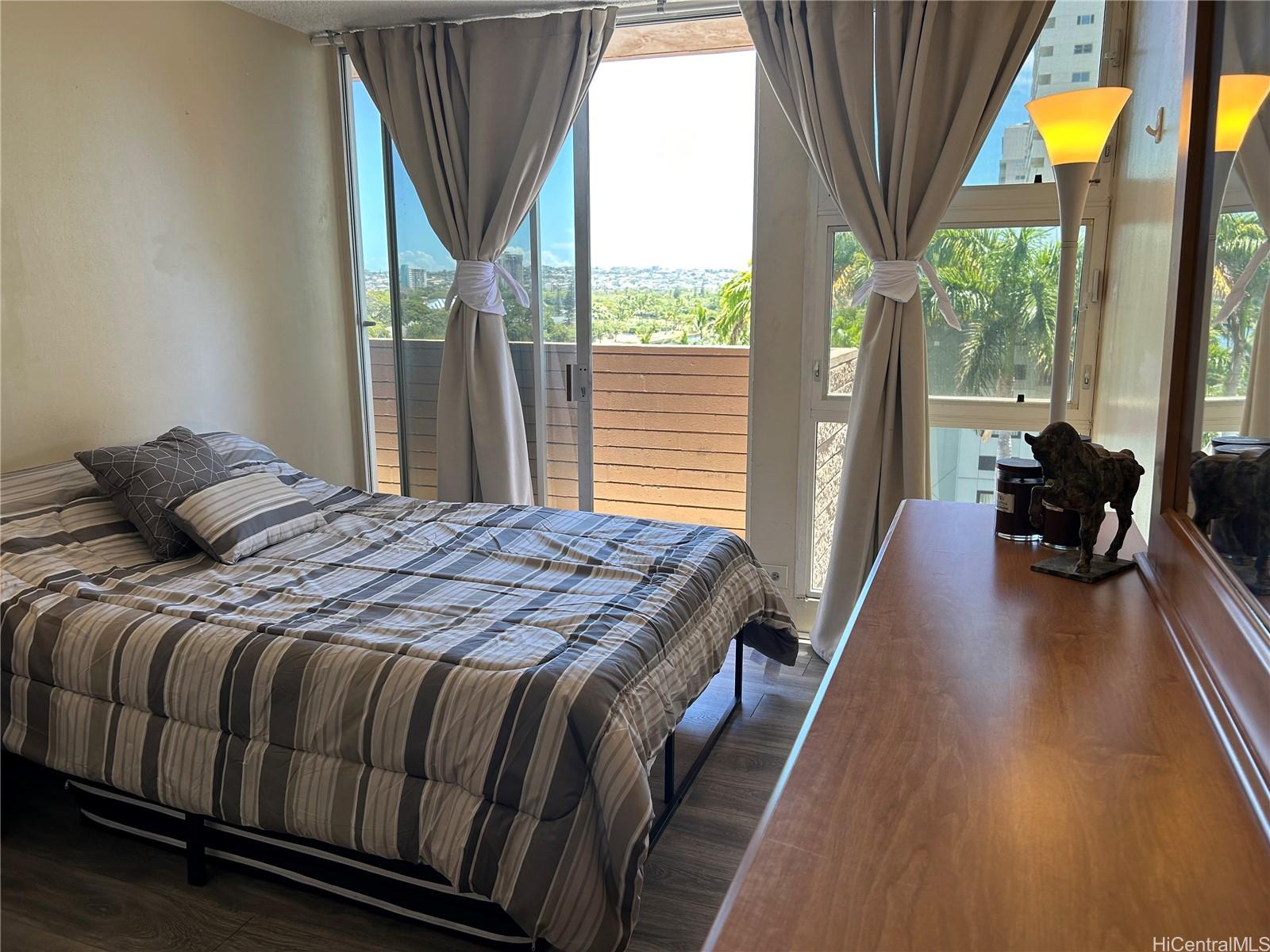 454 Nāmāhana Street, Unit 701 Honolulu, HI 96815 - Photo 21 of 25 a bedroom with a bed and wooden floor
