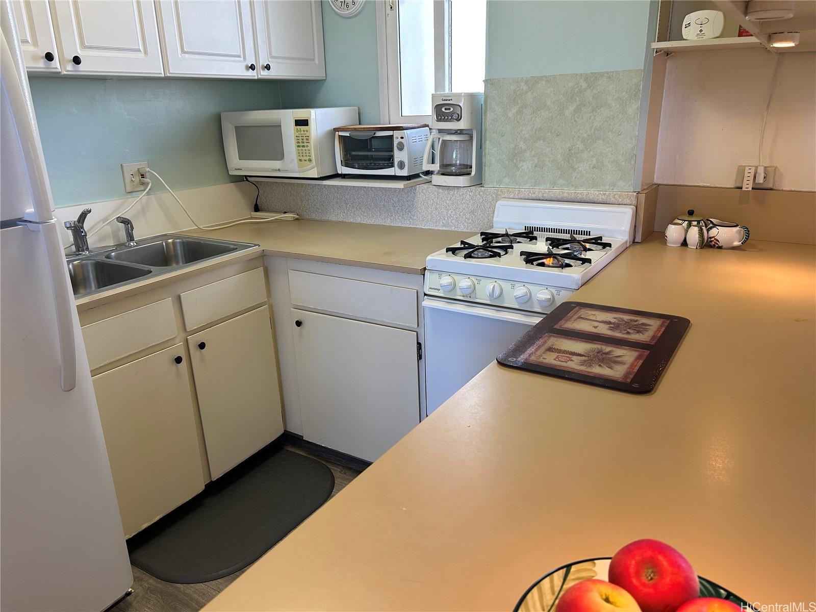 454 Nāmāhana Street, Unit 701 Honolulu, HI 96815 - Photo 23 of 25 a kitchen with a sink and cabinets