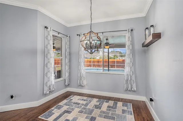 a view of empty room with window and wooden floor