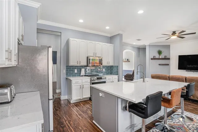 a kitchen with a table chairs refrigerator and microwave