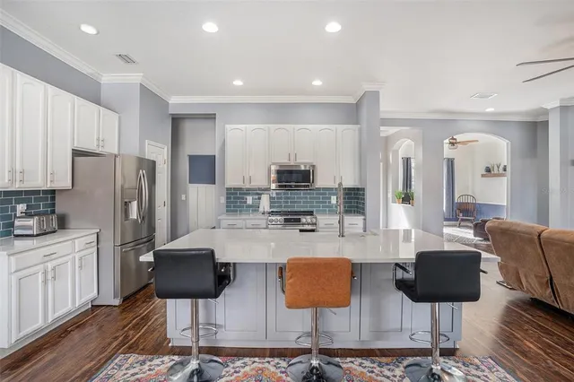 a kitchen with stainless steel appliances granite countertop a stove refrigerator and cabinets