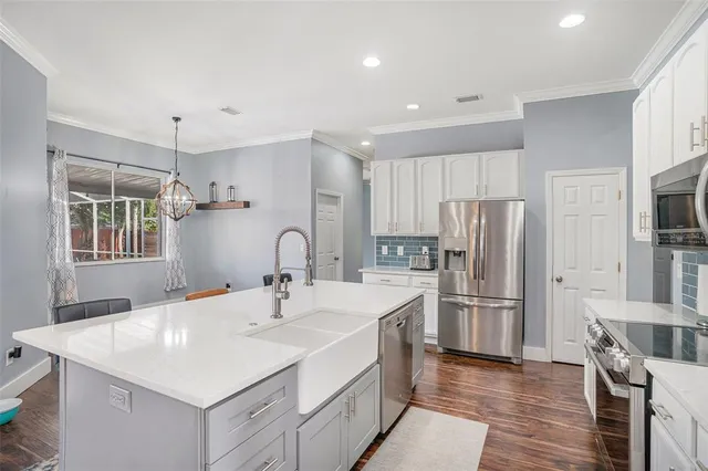 a kitchen with refrigerator cabinets and wooden floor