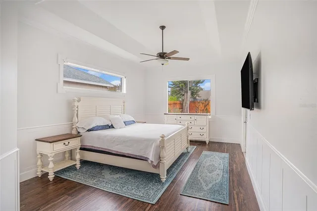 a bedroom with a bed and a flat tv screen on a dresser