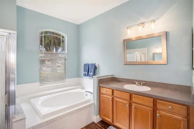 a bathroom with a sink a bathtub and a window