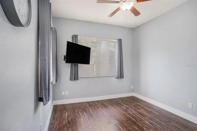 a view of room with wooden floor and ceiling fan