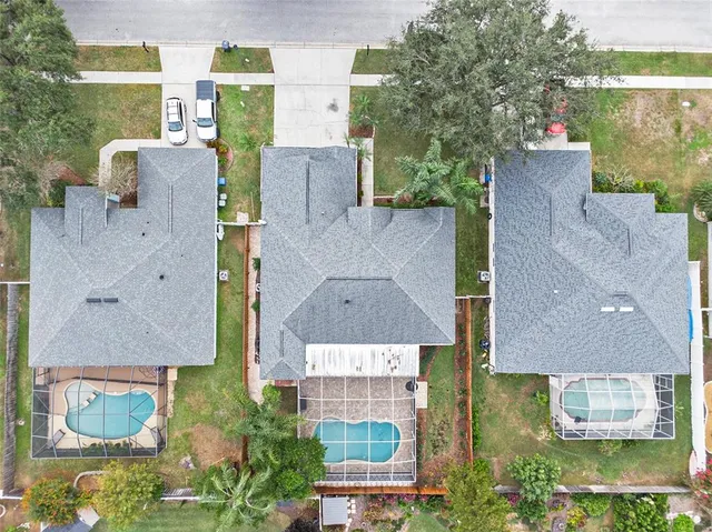 an aerial view of multiple houses with outdoor space and lake view