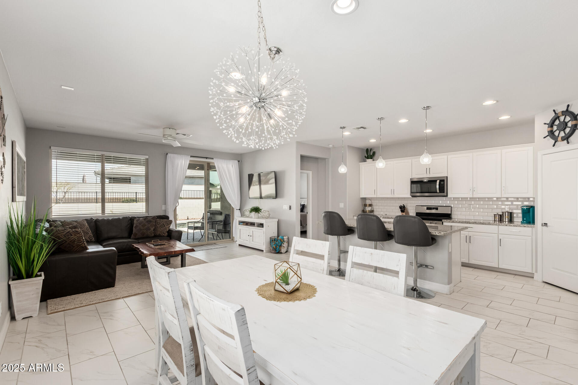 17784 West Sandy Road Goodyear, AZ 85338 - Photo 11 of 38 a large white kitchen with lots of counter space and chandelier