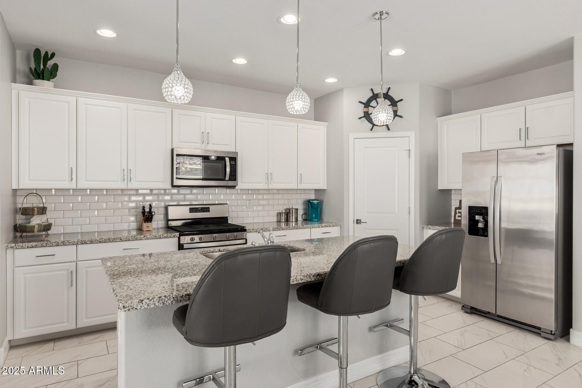 17784 West Sandy Road Goodyear, AZ 85338 - Photo 15 of 38 a kitchen with stainless steel appliances granite countertop a sink a stove a refrigerator cabinets and chairs