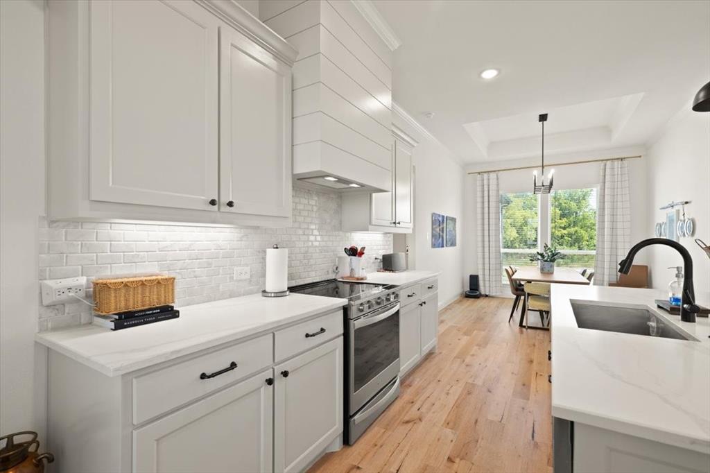 1028 Gatlin Circle Springtown, TX 76082 - Photo 13 of 30 a kitchen with white cabinets a sink dishwasher and white appliances with wooden floor