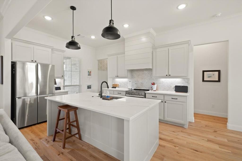 1028 Gatlin Circle Springtown, TX 76082 - Photo 8 of 30 a kitchen with a white center island a sink stainless steel appliances and cabinets