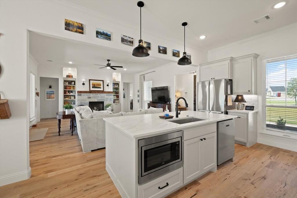 1028 Gatlin Circle Springtown, TX 76082 - Photo 10 of 30 a large kitchen with stainless steel appliances kitchen island granite countertop a stove a sink a refrigerator and a wooden cabinets