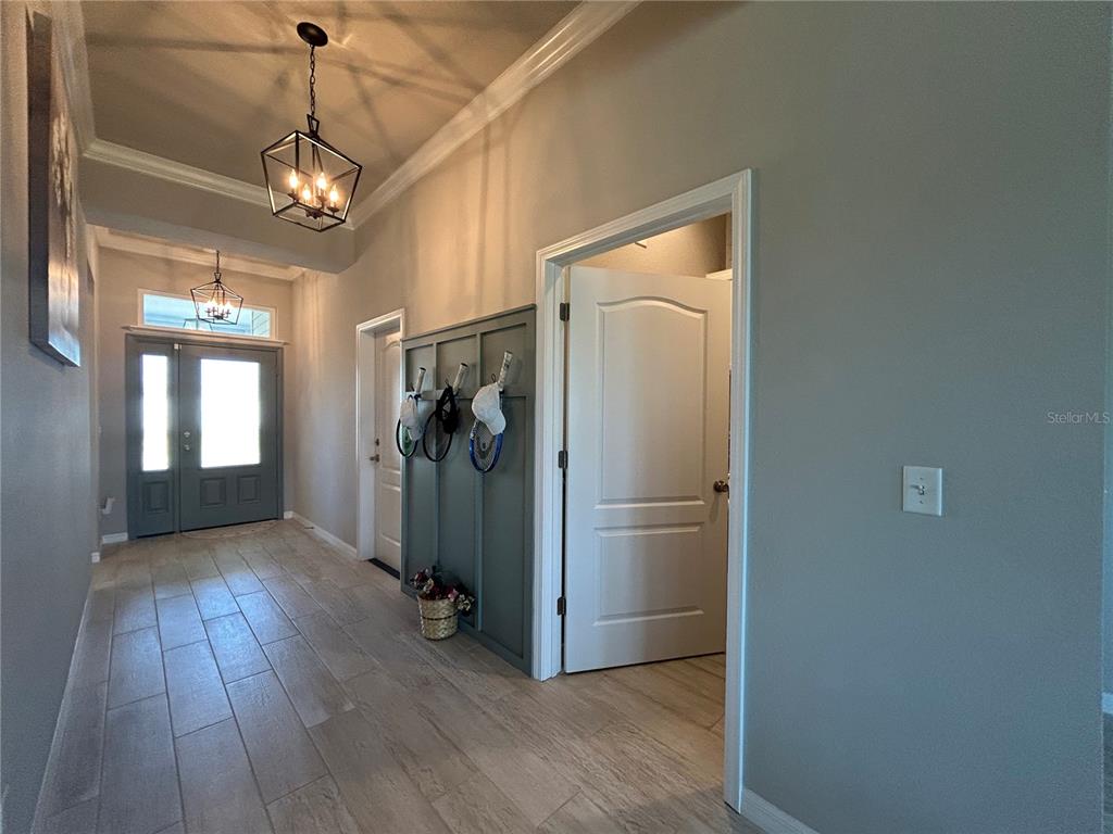 12101 Southwest 29 Place Gainesville, FL 32608 - Photo 13 of 26 a view of a hallway with wooden floor and a chandelier
