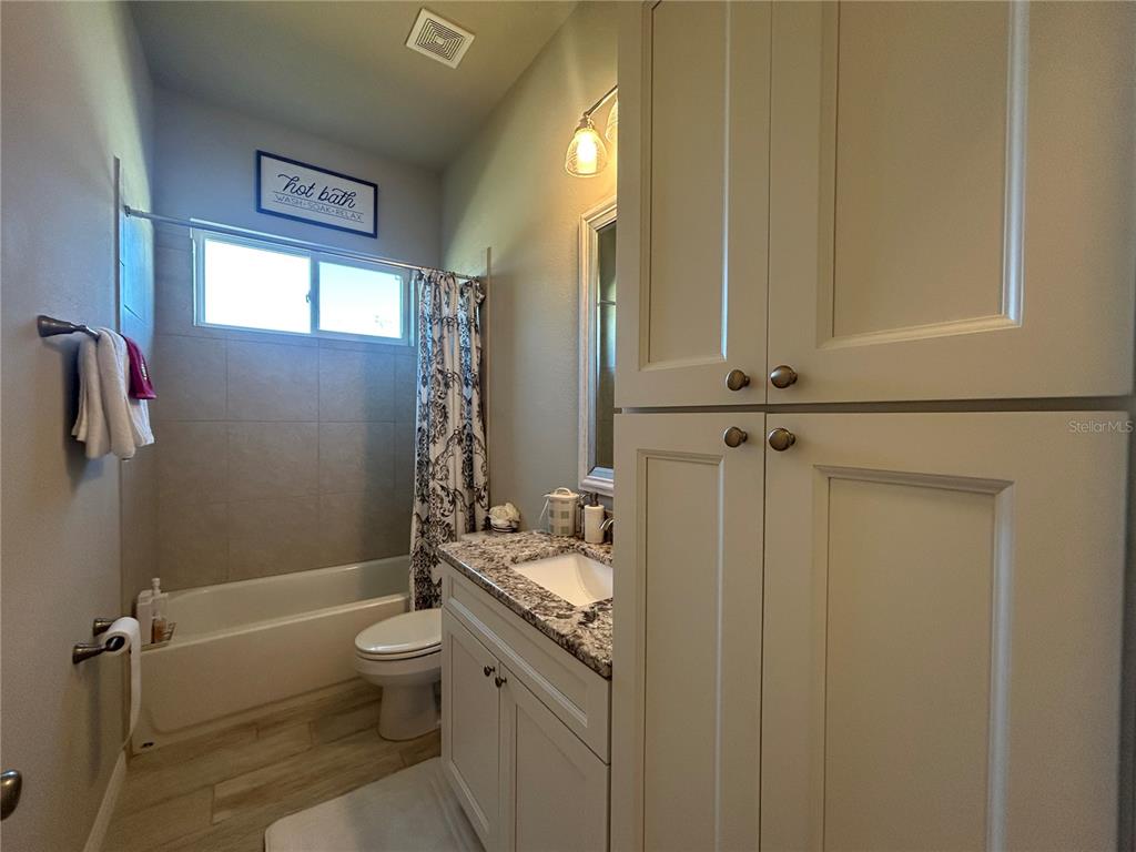 12101 Southwest 29 Place Gainesville, FL 32608 - Photo 17 of 26 a bathroom with a granite countertop sink toilet and shower