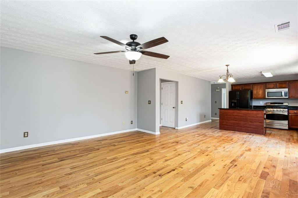 3721 Bogan Mill Road Northeast Buford, GA 30519 - Photo 13 of 58 a view of kitchen and empty room with wooden floor