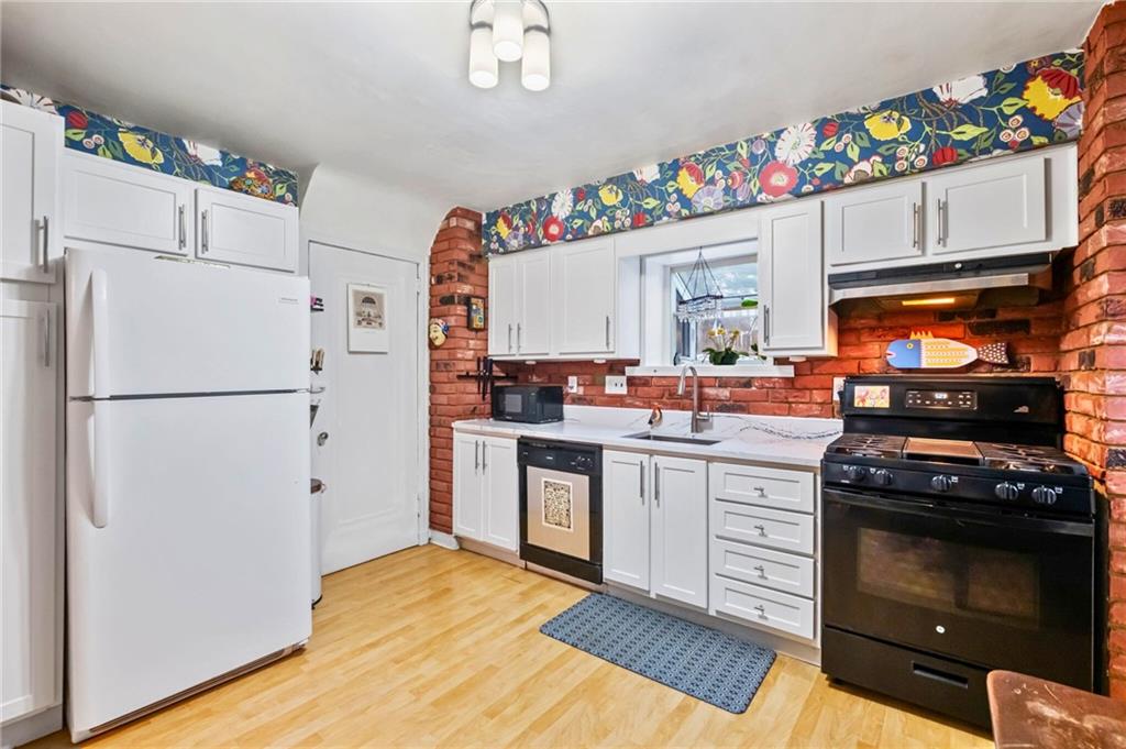 173 Spring Grove Road Pittsburgh, PA 15235 - Photo 14 of 30 a kitchen with granite countertop a stove a sink dishwasher and a refrigerator with wooden floor