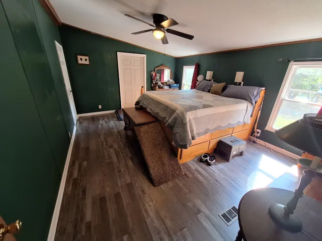 a bedroom with a bed and wooden floor
