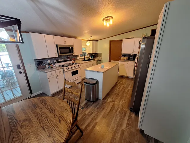 a kitchen with stainless steel appliances a refrigerator and a stove top oven