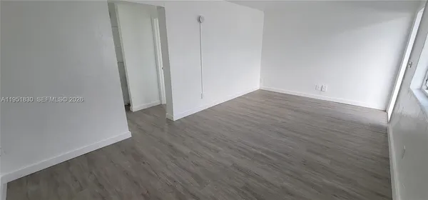 a view of a room with wooden floor