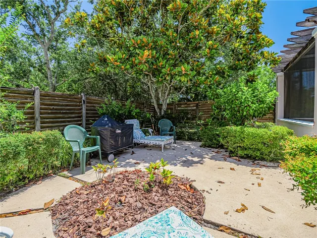 a view of a backyard with chairs and a potted plant