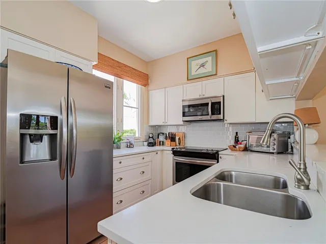 a kitchen with stainless steel appliances a refrigerator sink and microwave
