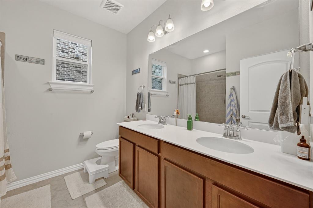 11320 Twisting Peak Road Fort Worth, TX 76052 - Photo 16 of 23 a bathroom with a toilet sink double vanity and mirror