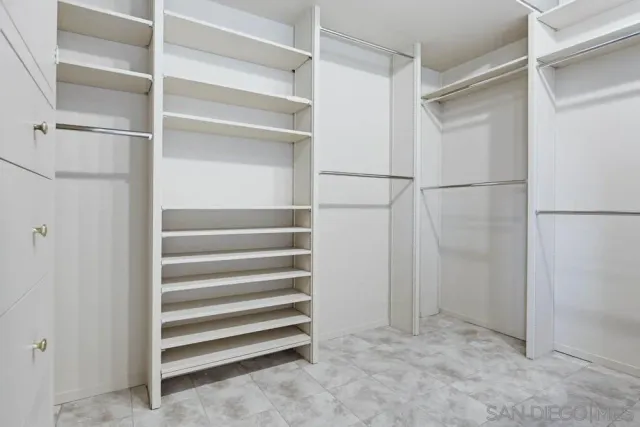 a view of walk in closet with empty racks