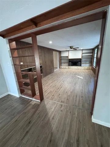 a view of empty room with wooden floor and fireplace