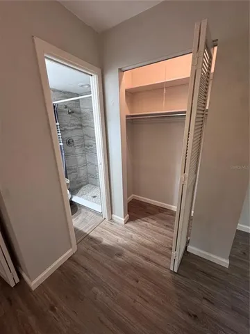 an empty room with wooden floor and entrance