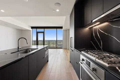 a kitchen with granite countertop a stove and a sink