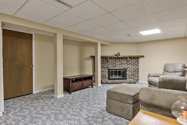 a living room with furniture a fireplace and a ceiling fan