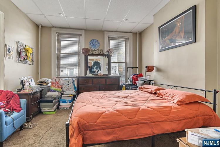 14-16 Crown Street Bloomfield, NJ 07003 - Photo 12 of 27 a bedroom with a bed a table and chair