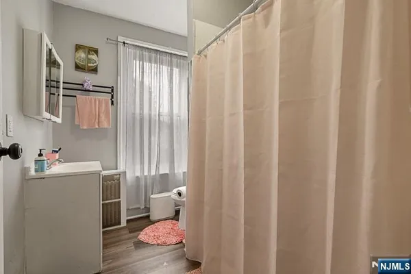 a bathroom with a sink toilet and shower curtain