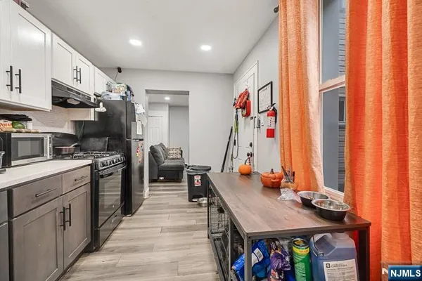 a kitchen that has a lot of cabinets a sink and a wooden floor