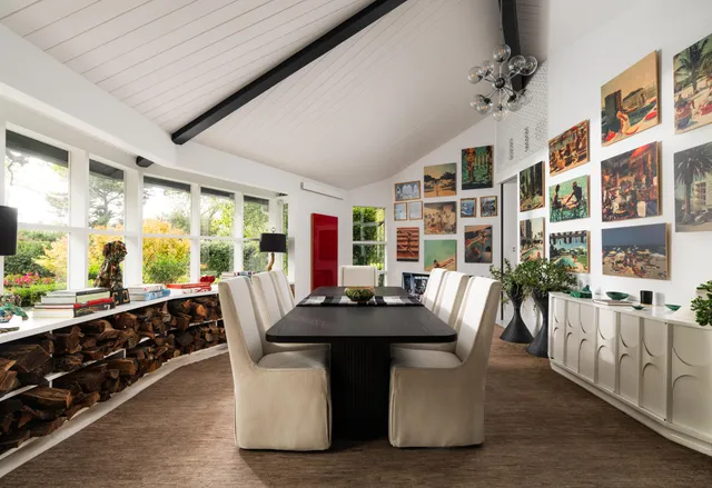 a dining room with furniture and large windows