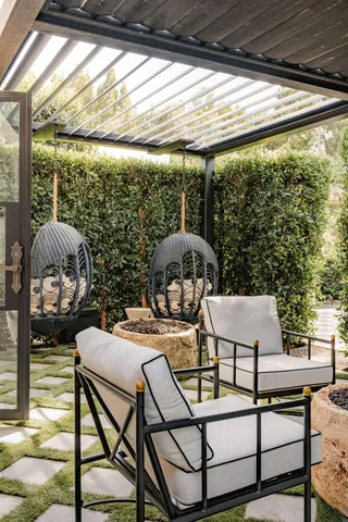 a view of a patio with table and chairs under an umbrella with a large tree