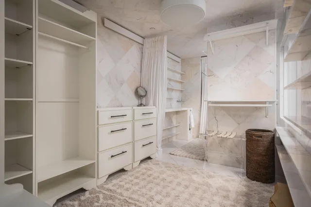 a view of walk in closet with clothes