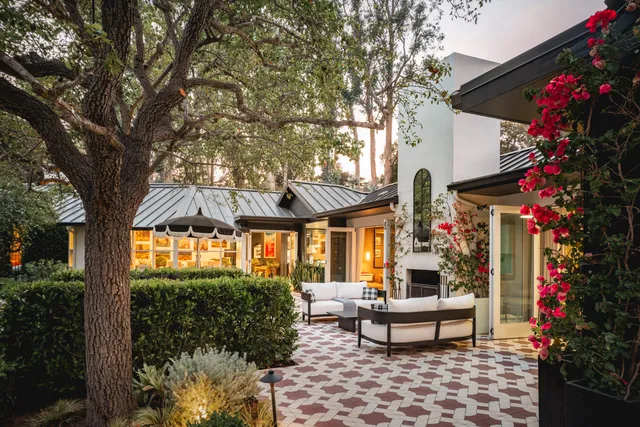 a front view of a house with a yard and trees