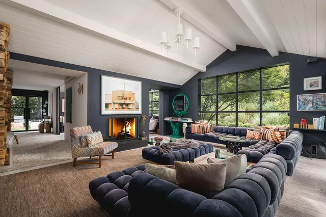 a living room with furniture a fireplace and a large window