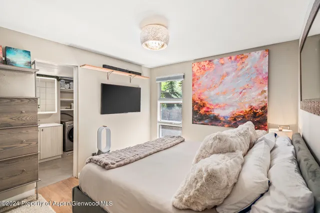 a bedroom with a bed and a flat screen tv