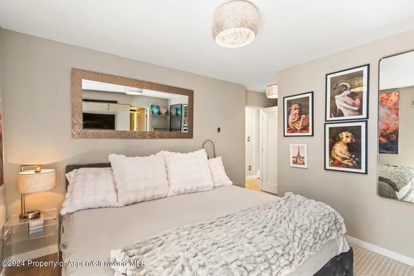 a bedroom with a bed and painting on the wall