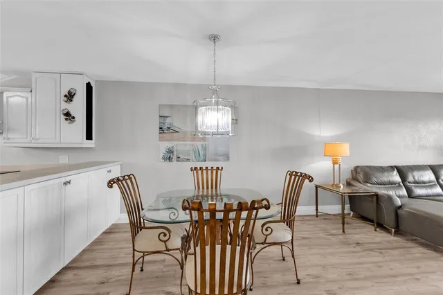 a view of a dining room with furniture a chandelier and wooden floor
