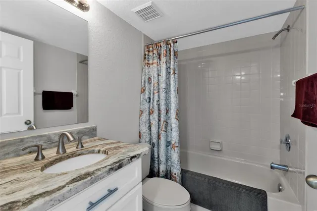 a bathroom with a granite countertop sink toilet mirror and shower