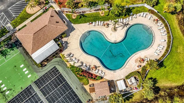 an aerial view of a swimming pool with outdoor seating and entertaining space