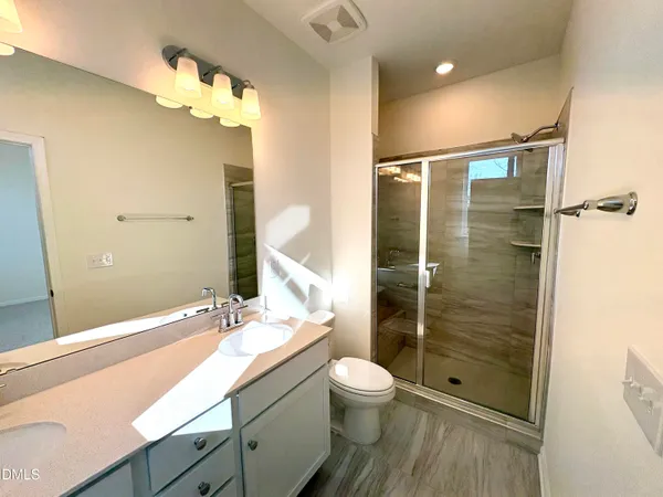 a bathroom with a double vanity sink mirror and toilet