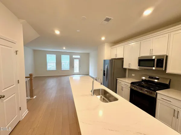 a kitchen with stainless steel appliances granite countertop a refrigerator a stove top oven a sink and dishwasher